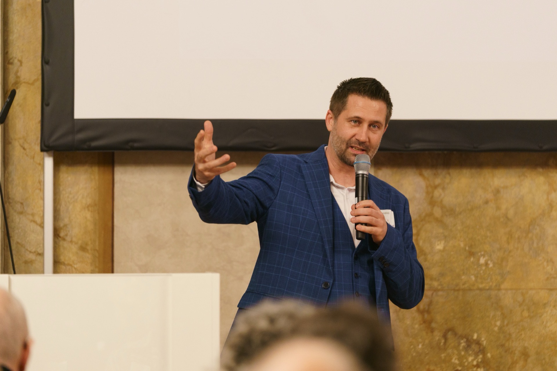 Christoph Wirl spricht mit Mikrofon vor Publikum