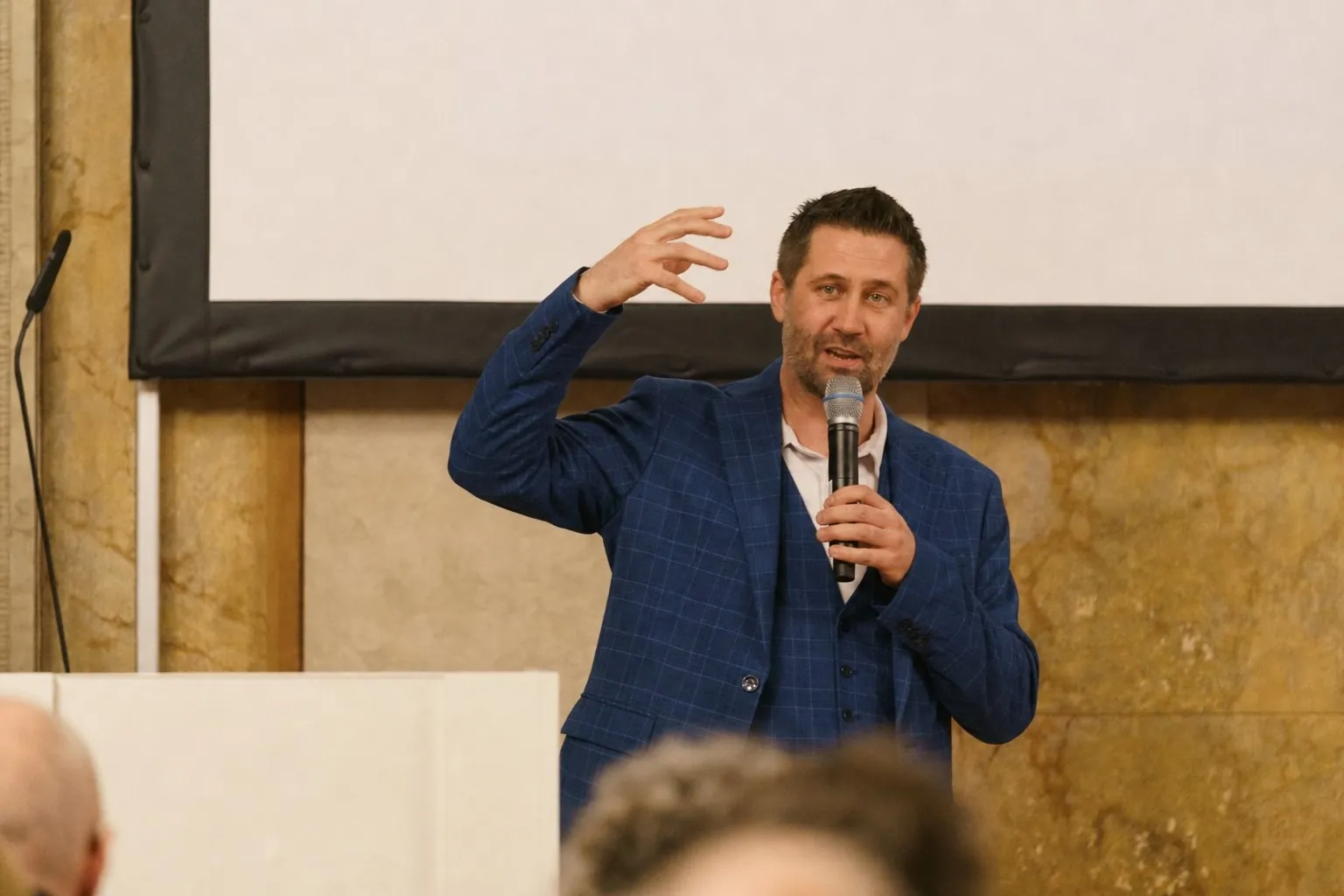 Christoph Wirl spricht mit Mikrofon vor Publikum